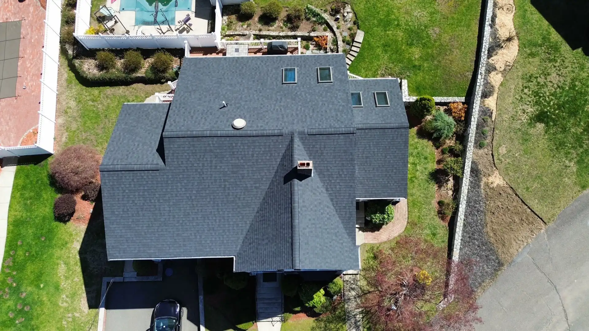Insurance adjuster inspecting storm damage on a Massachusetts roof