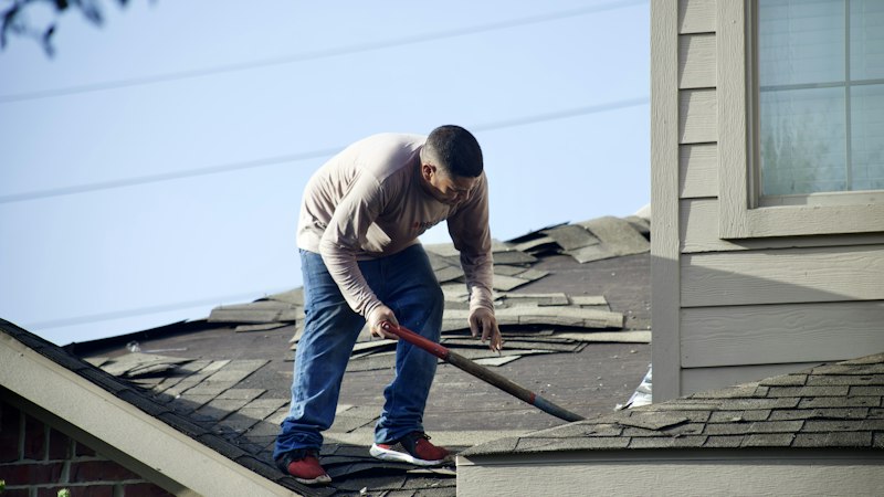 Roofer documenting storm damage for insurance in Massachusetts